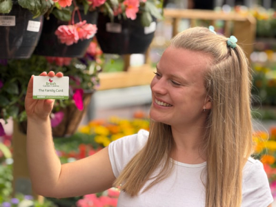 A woman holding up the loyalty card
