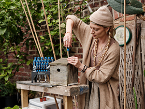 A lady with a bird box - encouraging birds into the garden a top trend