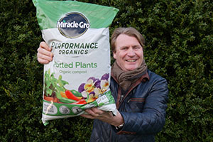 David Domoney - Chartered Horticulturalist - holding up bag of Evergreen Garden Care as he becomes their new brand ambassador