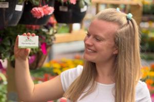 A woman holding up the loyalty card